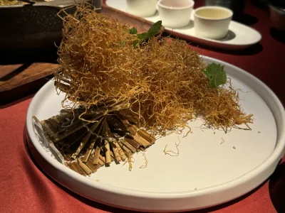Fine golden strands garnished with mint and presented on a white plate at Chang An Club in Xi'an