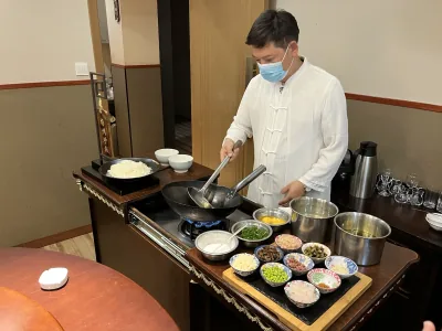 Chef Xia preparing Yangzhou fried rice beside a table of ingredients