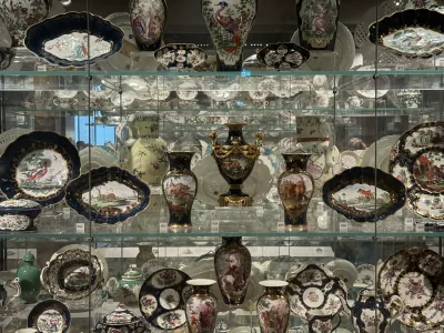 Decorated porcelain vases and plates displayed on glass shelves at the Ashmolean Museum in Oxford