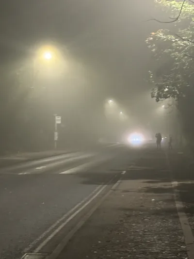 Streetlights and headlights glowing through thick fog outside Oxford's IBME building on Halloween night